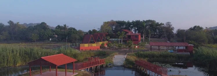 Amanecer sobre el campo, las palapas y el puente de acceso