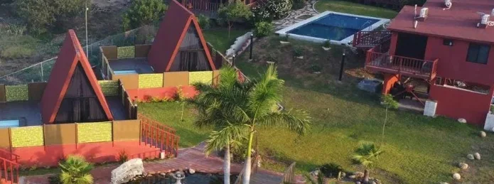 Vista aérea de las cabañas tipo teepee, la alberca y los jardines
