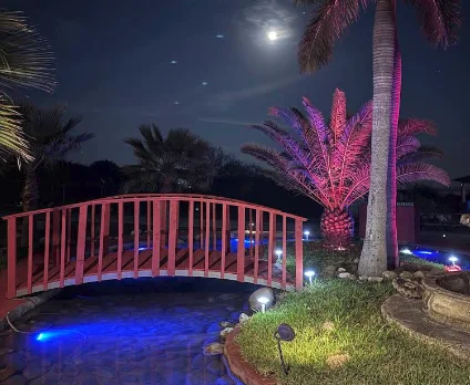 Puente rojo iluminado sobre el estanque, de noche